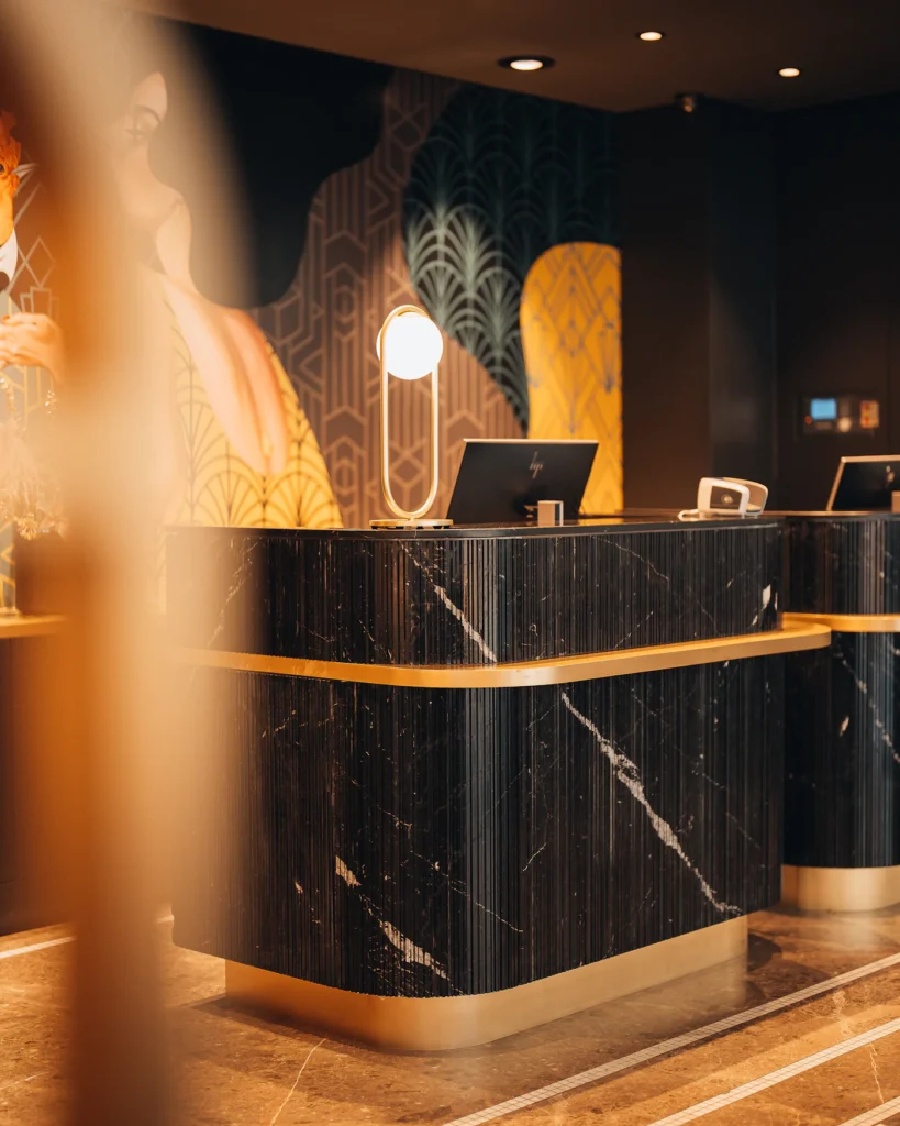 Dark marble hotel reception desk with a computer screen